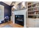 Close up of the study's fireplace with mantel, built-in shelving, and hardwood flooring at 2101 Hunters Green Dr, Lawrenceville, GA 30043