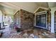 Cozy front porch with stone flooring, brick accents, and seating area perfect for relaxation at 2101 Hunters Green Dr, Lawrenceville, GA 30043