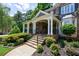 Inviting front porch with stone steps, white columns, wrought iron railing, and lush landscaping at 2101 Hunters Green Dr, Lawrenceville, GA 30043