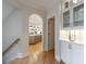Hallway view to a kitchen with hardwood floors, archway, and a lit glass cabinet at 2101 Hunters Green Dr, Lawrenceville, GA 30043