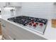 Kitchen cooktop with wolf cooktop and red knobs on a white countertop with white subway tile at 2101 Hunters Green Dr, Lawrenceville, GA 30043