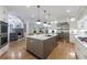 Open concept kitchen with large island, stone fireplace in the background, and stainless steel refrigerator at 2101 Hunters Green Dr, Lawrenceville, GA 30043