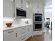 Kitchen with white cabinets, stainless steel double oven and microwave at 2101 Hunters Green Dr, Lawrenceville, GA 30043