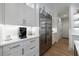 Bright kitchen features white cabinets, stainless steel refrigerator, and wood floors at 2101 Hunters Green Dr, Lawrenceville, GA 30043