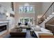 Open-concept living room with soaring windows, fireplace, and staircase access to the second floor at 2101 Hunters Green Dr, Lawrenceville, GA 30043
