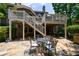 Charming outdoor patio beneath a deck, featuring stone flooring, a dining set, and access to upper level at 2101 Hunters Green Dr, Lawrenceville, GA 30043