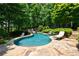 Backyard kidney-shaped pool and flagstone patio with lounge chairs surrounded by lush landscaping at 2101 Hunters Green Dr, Lawrenceville, GA 30043