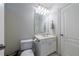 Simple powder room with vanity, toilet, and wall mirror in neutral tones at 2101 Hunters Green Dr, Lawrenceville, GA 30043