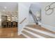 Elegant staircase with hardwood floors leading to a modern kitchen with bar seating at 2101 Hunters Green Dr, Lawrenceville, GA 30043