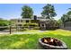 A stone fire pit with a wood deck and white home beyond awaits outdoor enjoyment at 290 Dania Dr, Alpharetta, GA 30009