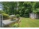 Private backyard featuring a patio with table and chairs, shed, and mature trees at 290 Dania Dr, Alpharetta, GA 30009