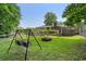 Backyard featuring a fire pit, swing, back deck, manicured lawn, and a border of trees at 290 Dania Dr, Alpharetta, GA 30009