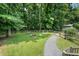 Backyard featuring a fire pit, swing, shed, manicured lawn, and a border of trees at 290 Dania Dr, Alpharetta, GA 30009