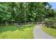 Backyard featuring a fire pit, swing, shed, manicured lawn, and a border of trees at 290 Dania Dr, Alpharetta, GA 30009