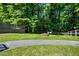 Lush backyard featuring a fire pit and swing set, surrounded by mature trees and well-maintained greenery at 290 Dania Dr, Alpharetta, GA 30009