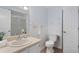 Well-lit bathroom featuring a vanity and toilet with a shower behind a glass door at 290 Dania Dr, Alpharetta, GA 30009