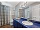 Well-lit bathroom featuring a blue vanity with a large mirror and a shower with a curtain at 290 Dania Dr, Alpharetta, GA 30009