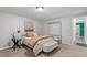 Bright bedroom featuring a comfortable bed with neutral bedding, stylish side table, and convenient closet space at 290 Dania Dr, Alpharetta, GA 30009