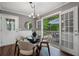 Dining area with seating and a view through french doors to the outdoor living and wooded area at 290 Dania Dr, Alpharetta, GA 30009