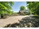 Landscaped exterior featuring an outdoor patio, mature trees, and a long driveway, offering curb appeal at 290 Dania Dr, Alpharetta, GA 30009