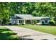 Charming one-story home with a long driveway and lush green lawn surrounded by mature trees at 290 Dania Dr, Alpharetta, GA 30009