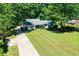 Well-manicured front yard with a lush green lawn, a long driveway, and mature trees, enhancing curb appeal at 290 Dania Dr, Alpharetta, GA 30009