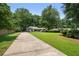 Expansive front yard and long driveway leading up to a charming home surrounded by mature trees at 290 Dania Dr, Alpharetta, GA 30009