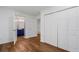 Hallway with hardwood floors leading to a bathroom with blue vanity, featuring a closet and doors at 290 Dania Dr, Alpharetta, GA 30009
