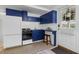 Bright kitchenette featuring dark blue cabinets, modern appliances, and a cozy table at 290 Dania Dr, Alpharetta, GA 30009