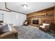 Living room with a brick fireplace, wooden wall, and chairs at 290 Dania Dr, Alpharetta, GA 30009