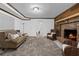 Cozy living room with a brick fireplace, gray carpet, wood accents, and wicker chairs at 290 Dania Dr, Alpharetta, GA 30009