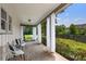 Inviting covered porch featuring brick flooring, sheer curtains, and cozy outdoor seating area at 290 Dania Dr, Alpharetta, GA 30009
