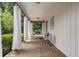 Covered porch with brick flooring, white curtains, and comfortable seating at 290 Dania Dr, Alpharetta, GA 30009