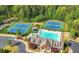 A beautiful aerial view showing the tennis courts and community pool, surrounded by lush greenery at 6477 Blue Water Dr, Buford, GA 30518