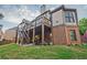 Exterior view of a multi-level home, showcasing a backyard, patio, and deck with stairs at 6477 Blue Water Dr, Buford, GA 30518