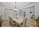 Elegant dining room with a modern table setting, a chandelier, and hardwood flooring at 6477 Blue Water Dr, Buford, GA 30518