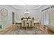 Formal dining room featuring a large table, elegant chandelier, and sophisticated decor at 6477 Blue Water Dr, Buford, GA 30518