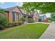 Well-maintained brick house boasting a lush green lawn, mature trees, and an attached two-car garage at 6477 Blue Water Dr, Buford, GA 30518