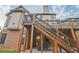 Exterior view of a two-story home featuring a deck with stairs, a patio, and brick accents at 6477 Blue Water Dr, Buford, GA 30518