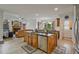 Open-concept kitchen with stainless steel appliances and an eat-in island that flows into the living room with fireplace at 6477 Blue Water Dr, Buford, GA 30518
