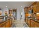 Well-lit kitchen featuring wooden cabinetry, stainless steel refrigerator, and granite countertops at 6477 Blue Water Dr, Buford, GA 30518
