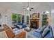 Elegant living room with large windows, a ceiling fan, and a fireplace as a focal point at 6477 Blue Water Dr, Buford, GA 30518