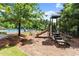 A modern community playground with slides and climbing equipment, nestled in a leafy, shaded area at 6477 Blue Water Dr, Buford, GA 30518