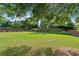 Lush backyard with large grassy area, privacy fence, and mature trees at 910 Ovalene Sw Ln, Marietta, GA 30064