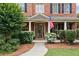 Close-up of a quaint front porch with brick columns and an American flag at 910 Ovalene Sw Ln, Marietta, GA 30064