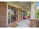 Inviting brick front porch featuring a welcome mat, comfortable seating, and classic architectural details at 910 Ovalene Sw Ln, Marietta, GA 30064