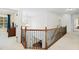 Bright hallway featuring hardwood railing, staircase, and open floor plan at 910 Ovalene Sw Ln, Marietta, GA 30064