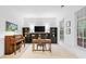 Cozy living room with built-in shelving, a piano, and large windows for natural light at 910 Ovalene Sw Ln, Marietta, GA 30064