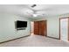 Large bedroom featuring carpet, ceiling fan, and a mounted TV for entertainment at 1757 Mystery Sw Cir, Conyers, GA 30094