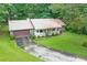 Charming single-Gathering home with a metal roof, stone accents, covered porch, and well-maintained lawn surrounded by lush trees at 1757 Mystery Sw Cir, Conyers, GA 30094